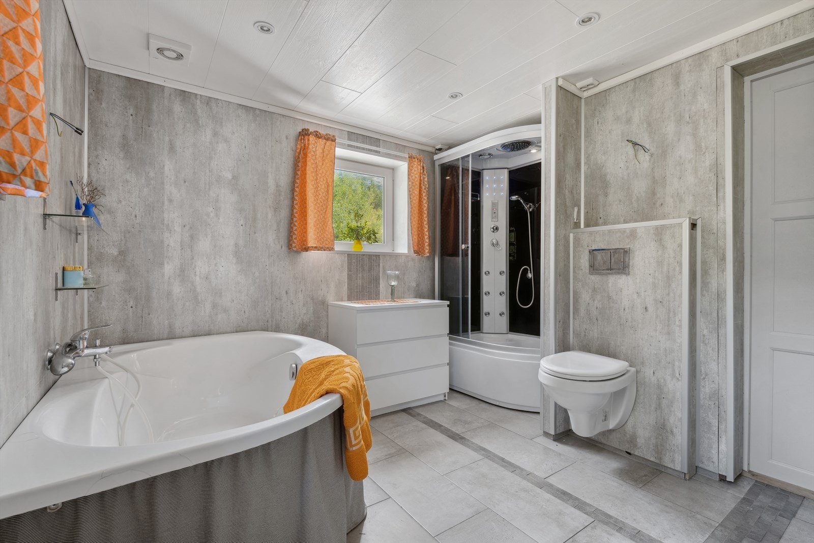 Badet er romslig med sine 10 kvm og innredet med flis på gulv og våtromsplater på veggene. Galleribilde