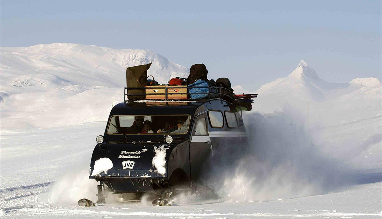 Vinterstid er det parkering ved Tyin, 20 km unna, og en kan benytte seg av ski, beltebil i rute eller snøscooter. Reisen med beltebil om vinteren er en eksotisk opplevelse. (Selgers foto). Galleribilde