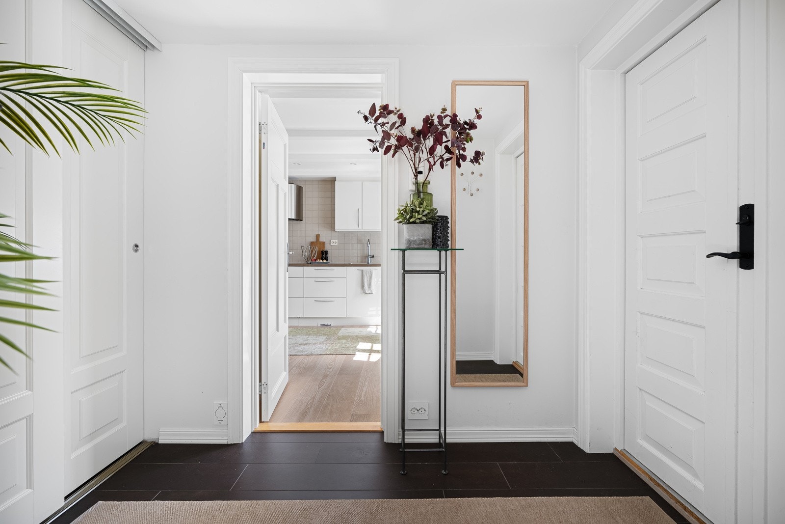 Entre med fliselagt gulv og skyvedørsgarderobe - dør inn til både stue og kjøkken Galleribilde