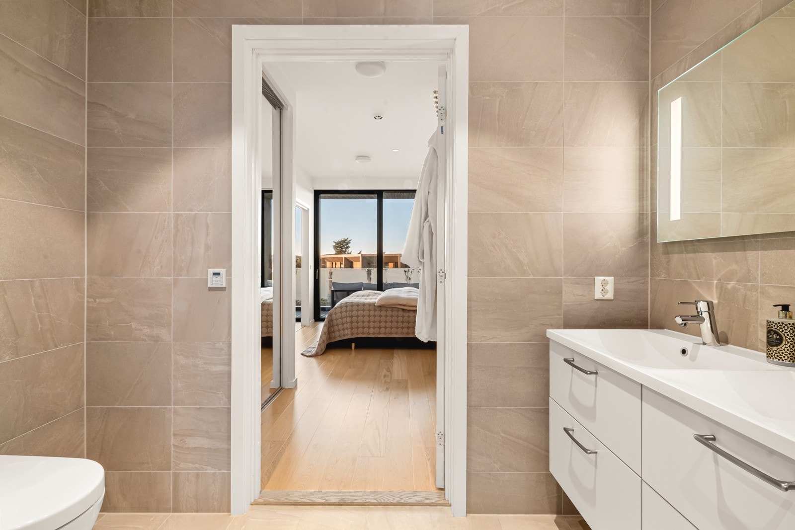 Badet har keramiske fliser på gulv og vegger og malte flater i himling med innfelte spotter. Galleribilde