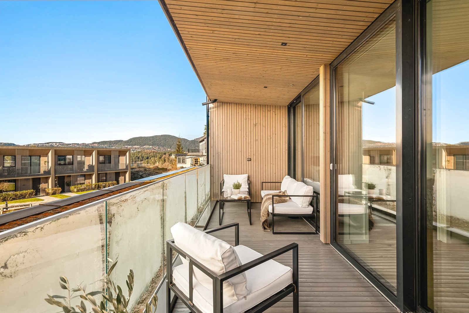 Her er det trykkimpregnerte terrassebord som nylig er beiset, glassrekkverk og spotter i himling. Galleribilde