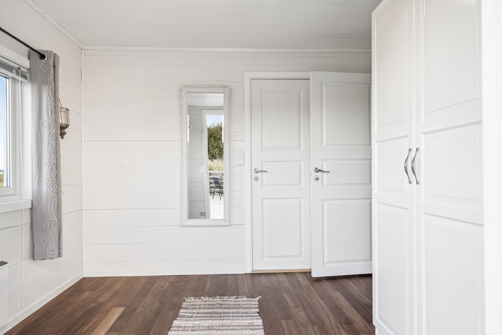 Lys entré med dør til bad/vaskerom. Galleribilde