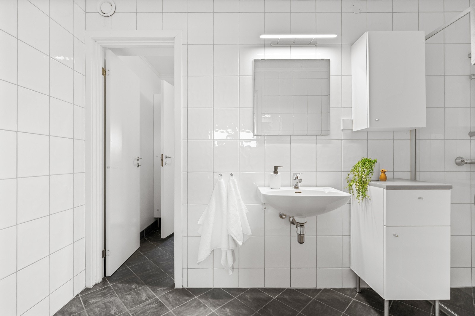 Stilrent helfliset bad med tilknyttet separat vaskerom. Galleribilde