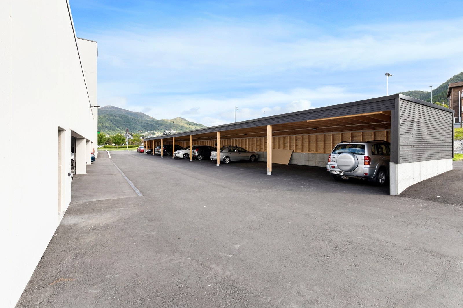 Leiligheten disponerer en parkeringsplass i felles carportrekke. Her er det montert elbil-lader. Galleribilde