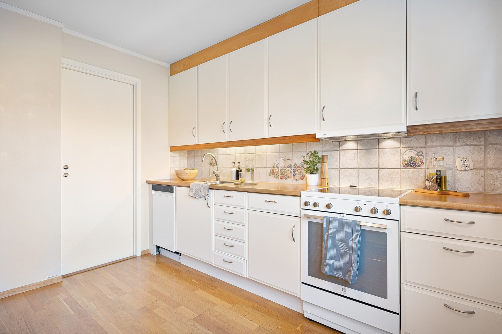 Kjøkkeninnredningen har profilerte fronter i malt utførelse Galleribilde