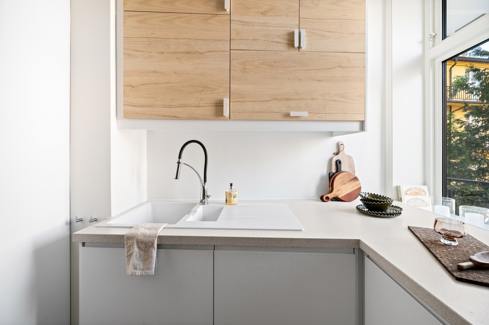 Kjøkkeninnredningen er av glatte fronter og benkeplate i laminat med nedfelt vask. Lyslist under overskap. Galleribilde