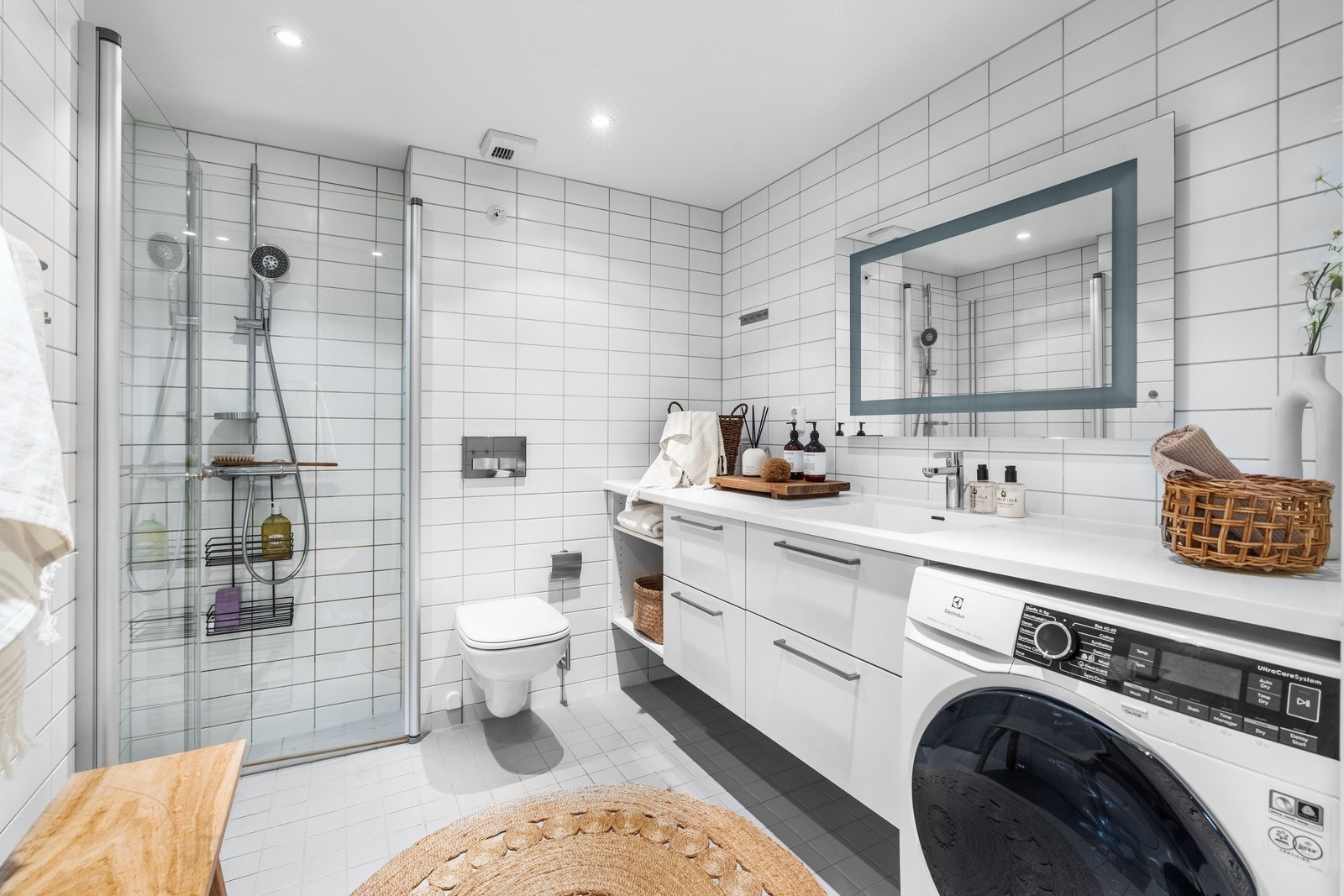Pent flislagt bad med dusj, WC, servant og vaskemaskin. Galleribilde