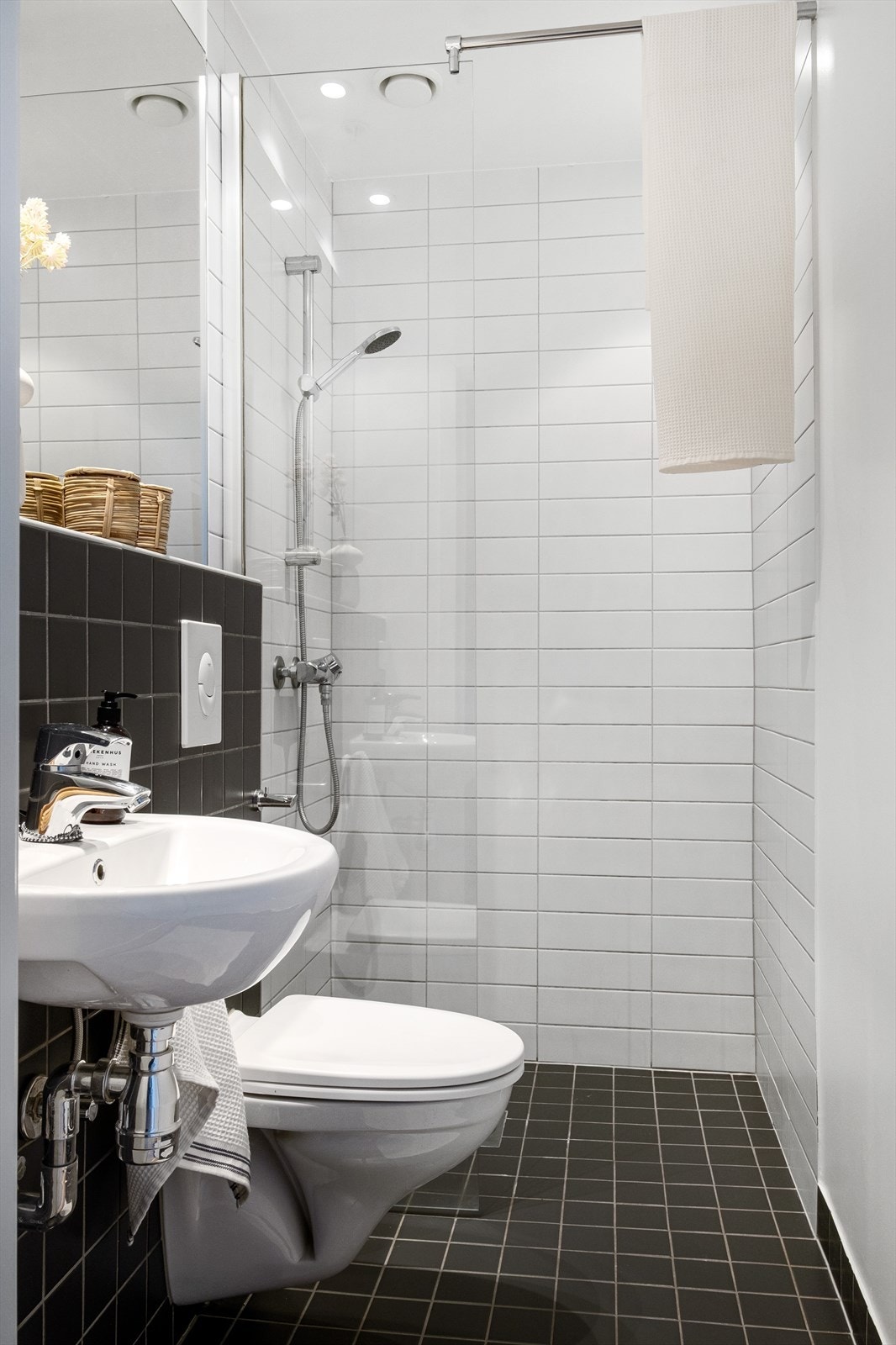 Flislagt baderom med varmekabler, avtrekk, speil, downlights, servant hjørne med innfellbare glassdører og vegghengt toalett. Galleribilde