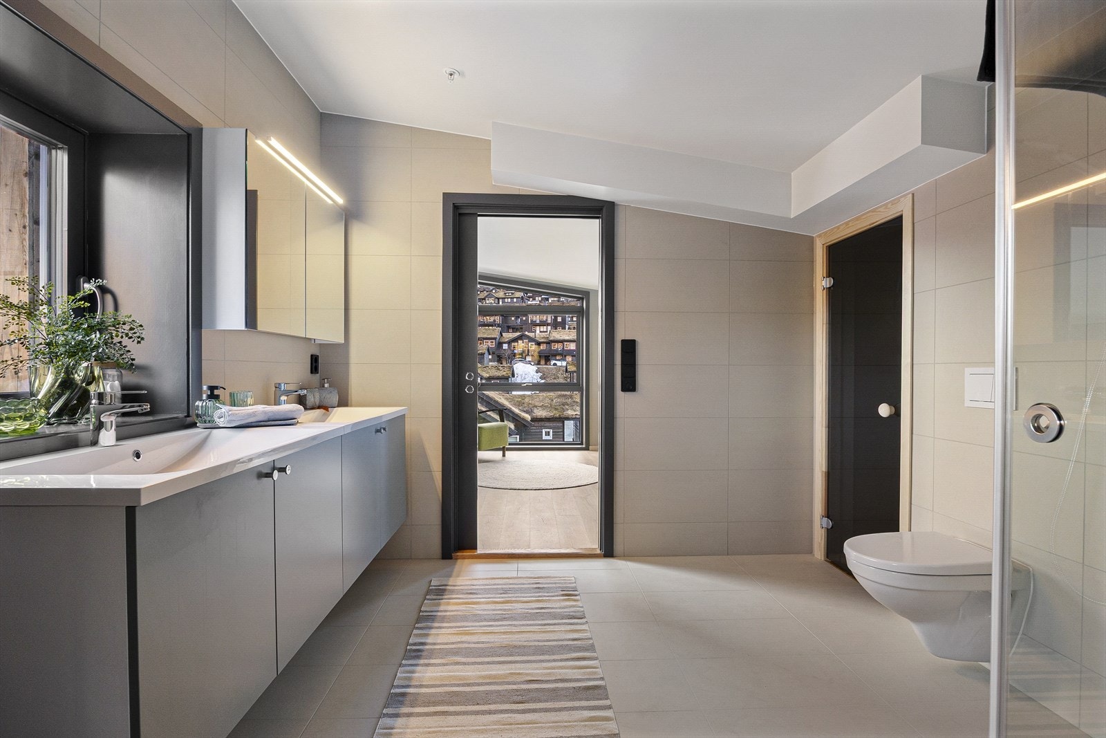 Fra loftsstuen finner du leilighetens suite. Her møtes du av et luksuriøst bad med dobbel servant, og med en spektakulær utsikt. Galleribilde