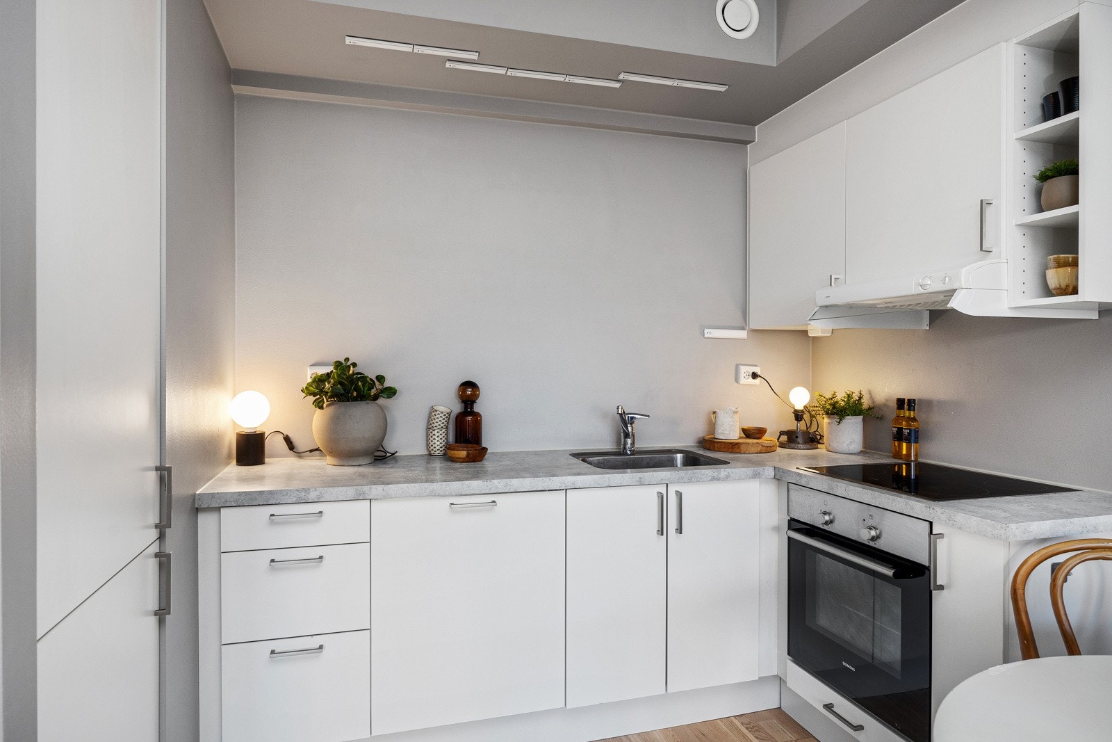 Tidløst kjøkken med integrerte hvitevarer og laminat benkeplate. Galleribilde