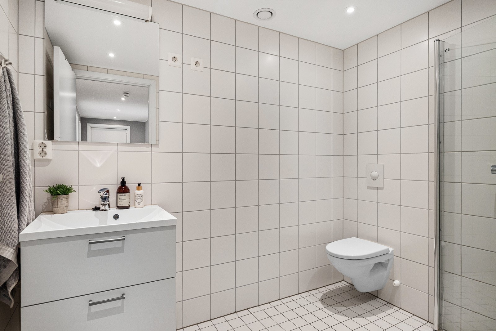 Lys, pent baderom med flislagte overflater og varme i gulvet. Galleribilde