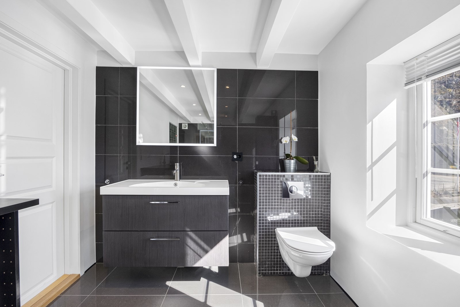 Badet er innredet med baderomsinnredning med skuffer, speil og vegghengt wc. Galleribilde