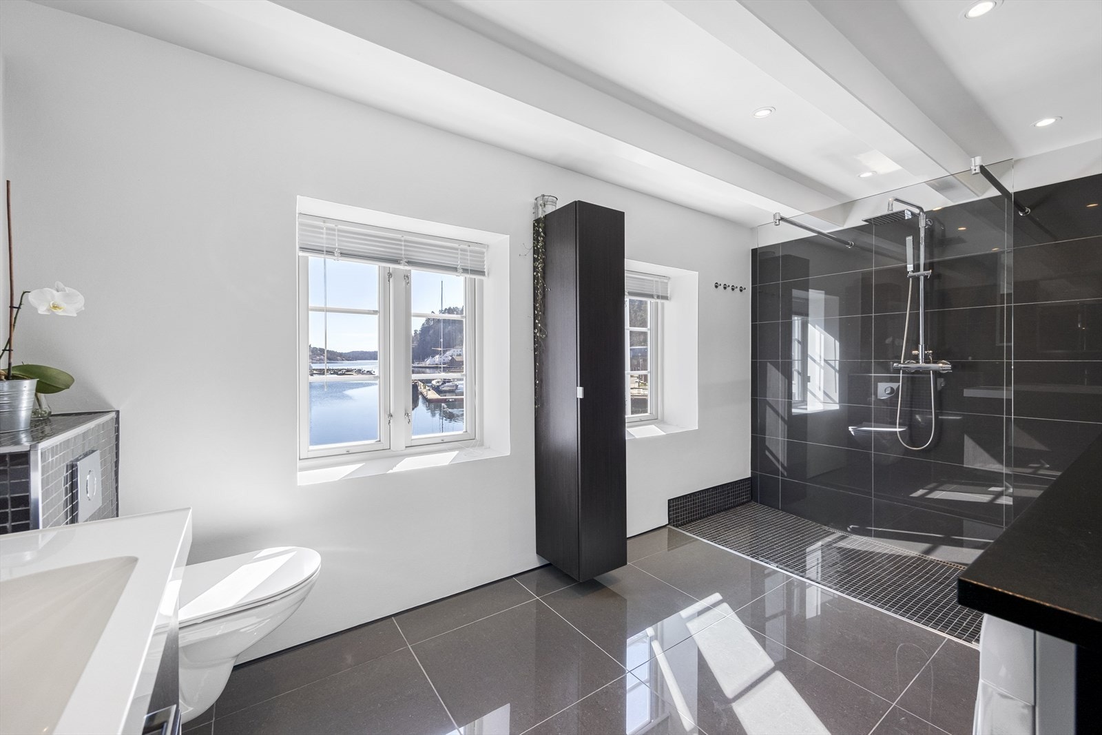 Lekkert, flislagt bad med varmekabler i gulv. Stor, deilig dusjnisje. Fra badet er det også nydelig utsikt. Downlights i tak. Galleribilde