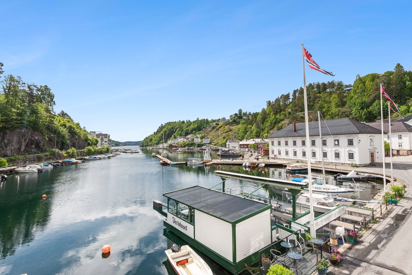 Utsikt fra veranda. Her har nåværende eier sittet mange sommerkvelder og nytt god mat og noe godt i glasset, mens de kan følge med på båtlivet og alt som rører seg i sentrum. Galleribilde
