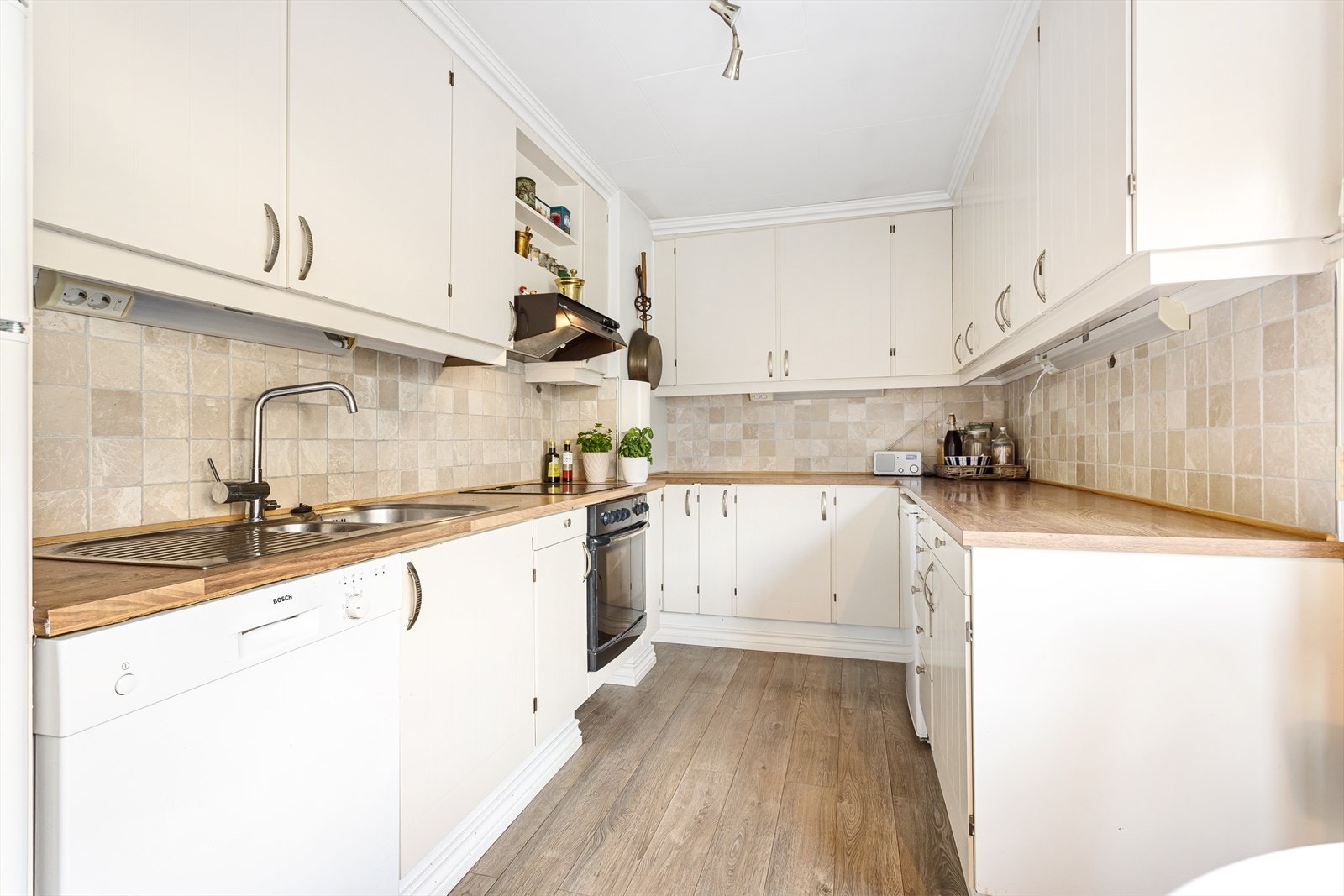 Integrert stekeovn og platetopp samt plass for frittstående oppvaskmaskin og kjøl/frys. Galleribilde