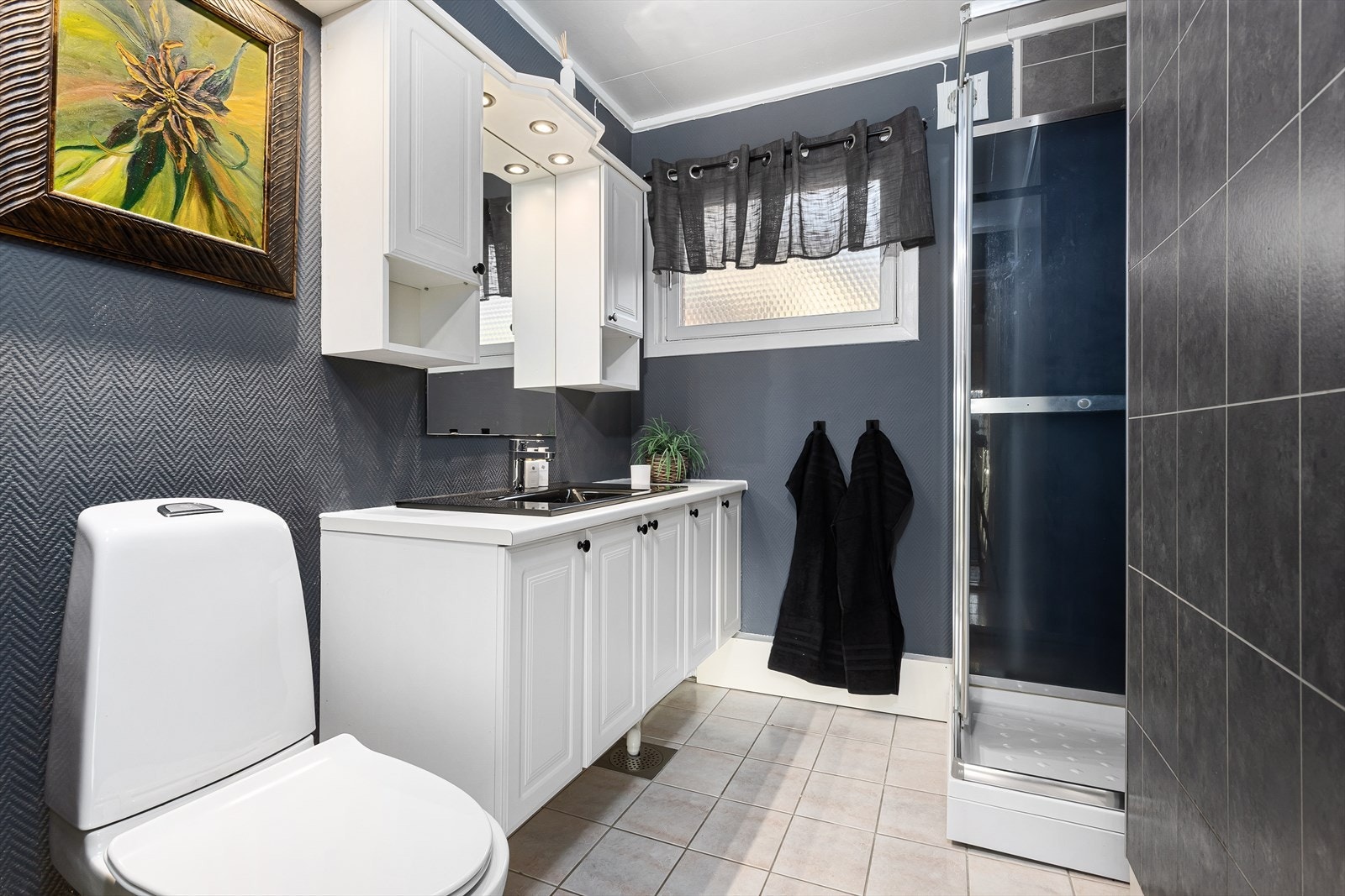 Badet er innredet med dusjkabinett, wc og en romslig baderomsinnredning. Varmekabler i gulv. Galleribilde