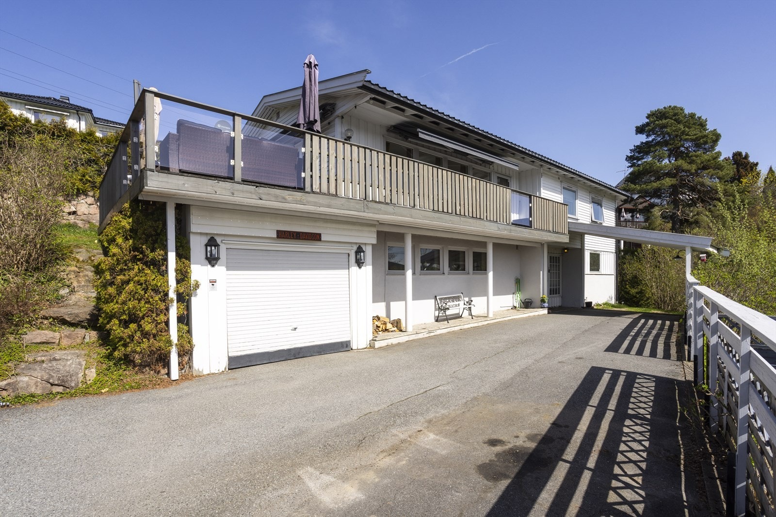 Asfaltert gårdsplass med garasje og overbygget inngangsparti Galleribilde