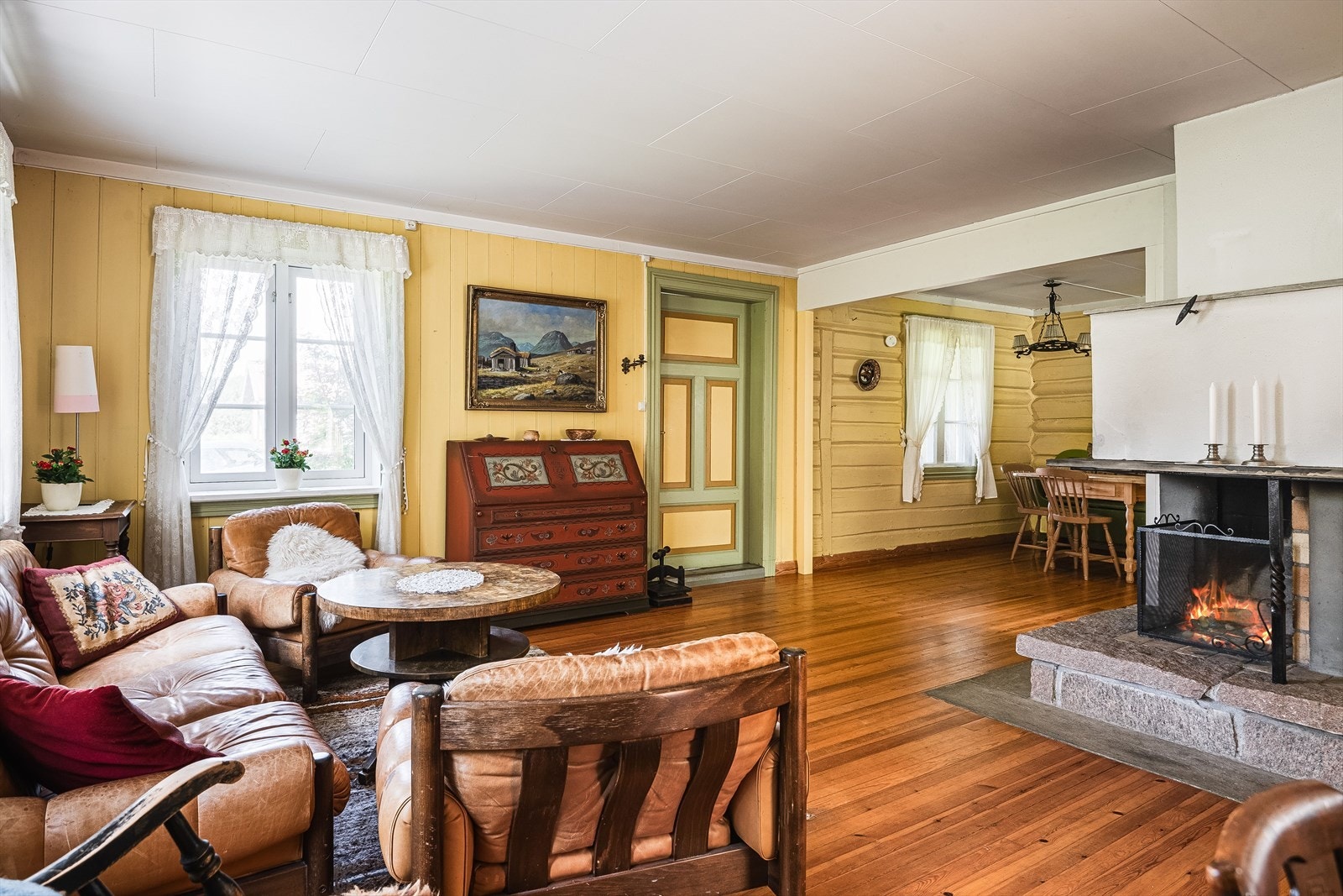 Også i denne stuen er det en koselig åpen peis som bidrar til ekstra hygge. Galleribilde