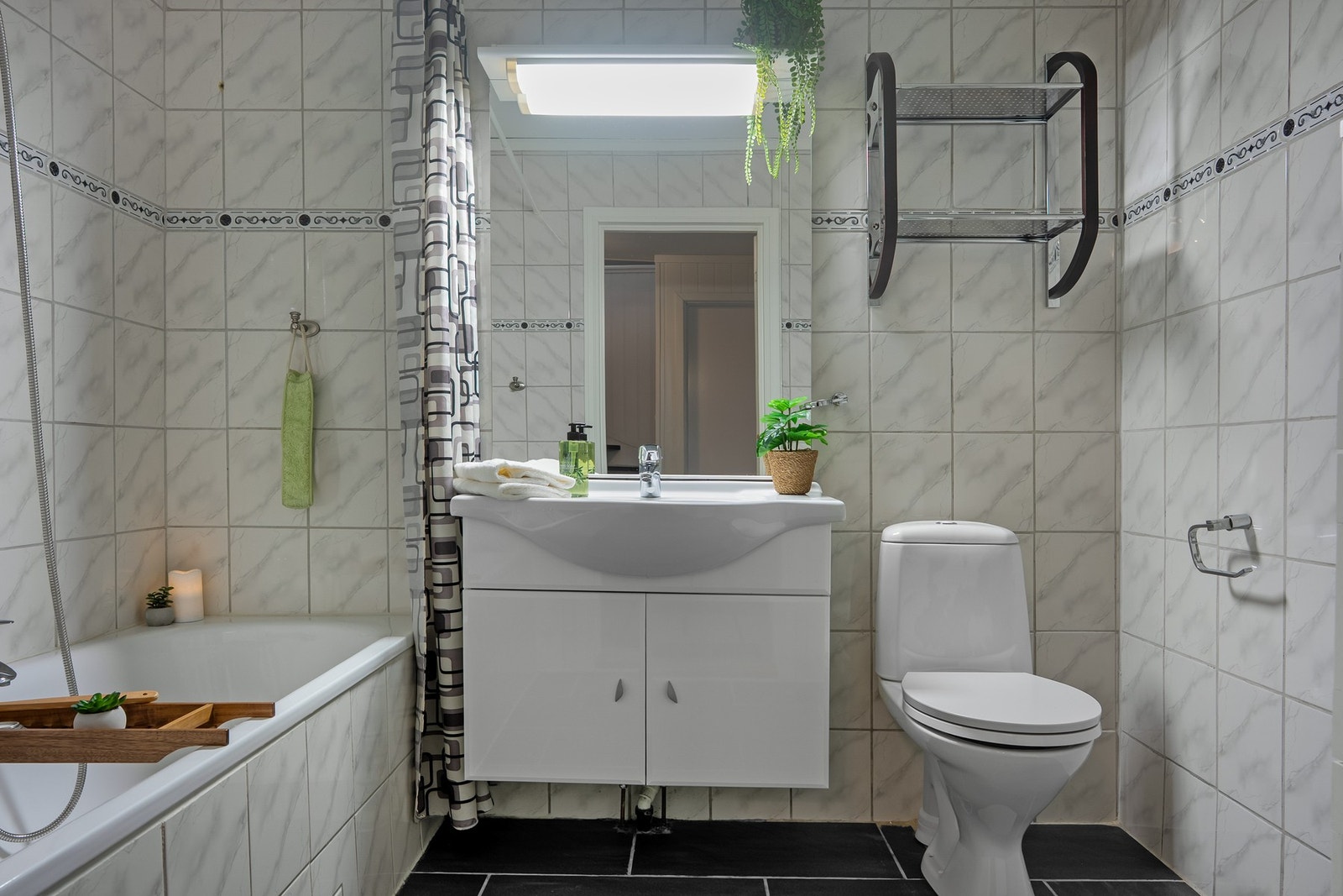 Badet i underetasjen er innredet med badekar, servant og toalett Galleribilde