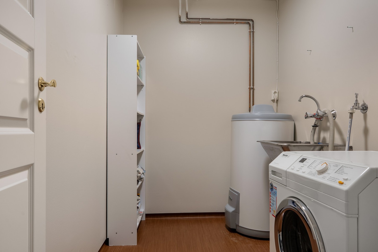 Praktisk vaskerom i underetasjen med utslagsvask og opplegg for vaskemaskin Galleribilde