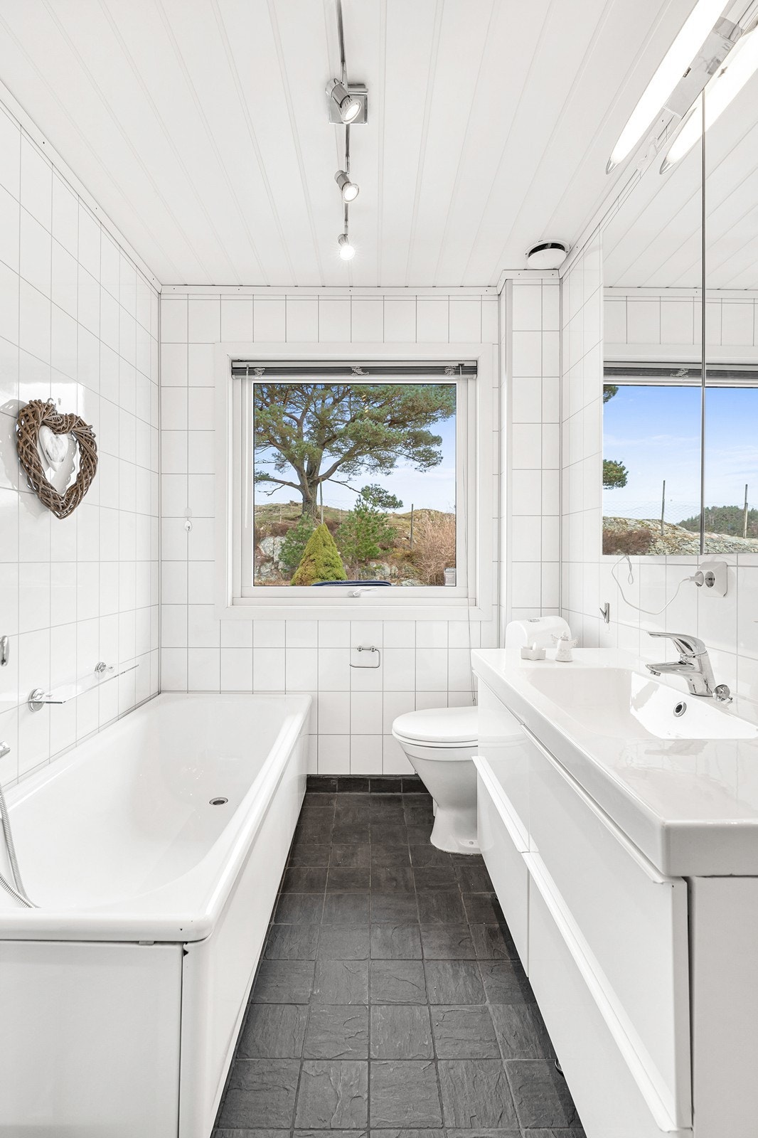 Badet har fliser på gulv med varmekabler og baderomsplater på vegger. Galleribilde