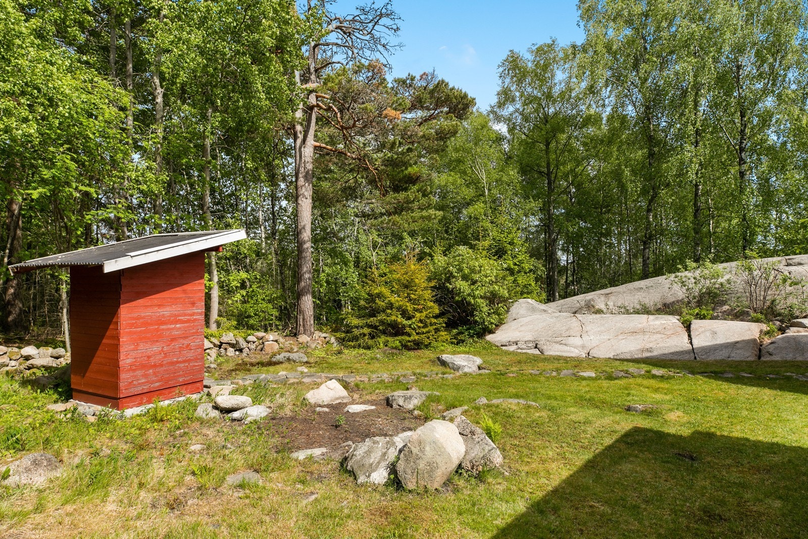 Det er stenlagt sti mot utedoen som ble oppført i ca år 2000. Galleribilde