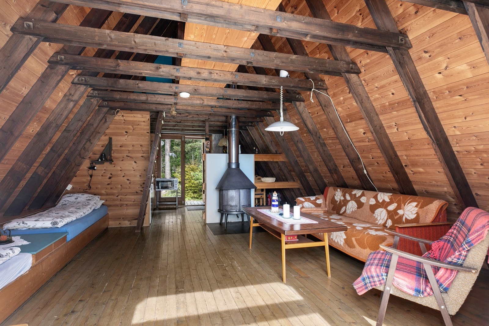 Det er åpent oppholdsrom helt opp til yttertaket. Vedovnen gir god og lun varme i rommet. Galleribilde