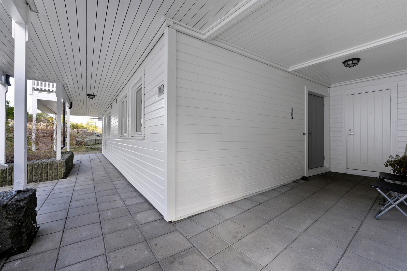 Inngang under tak med plass til et hyggelig cafésett Galleribilde