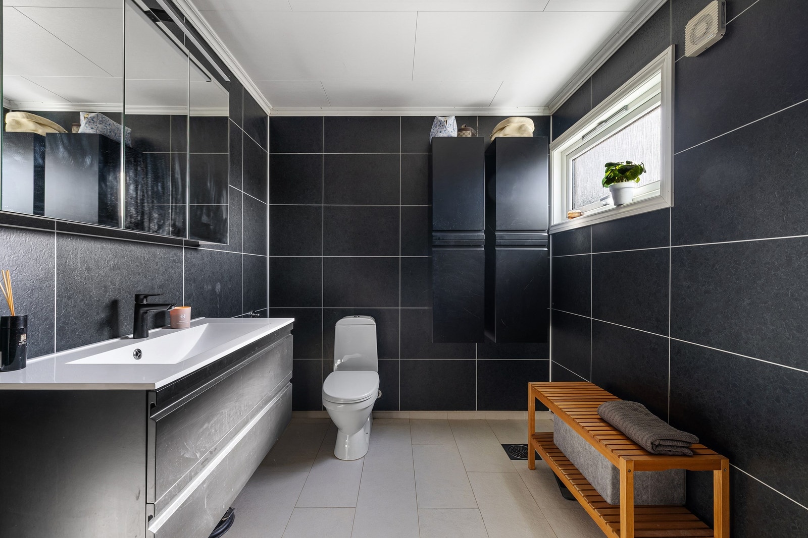 Gulvet er utført med fliser og varme, veggene med flismønstrede våtromsplater. Galleribilde