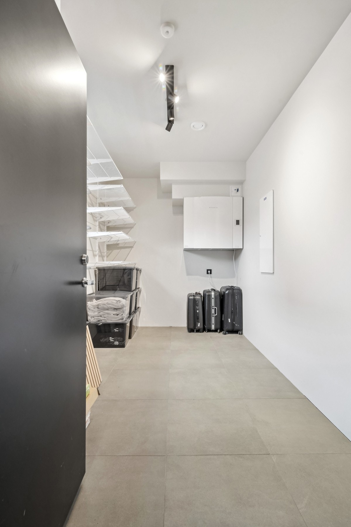 Fra garasjen er det tilkomst til en stor, isolert bod med gulvvarme og 60x60 fliser på gulvet. Montert hylleinnredning på vegg. Galleribilde