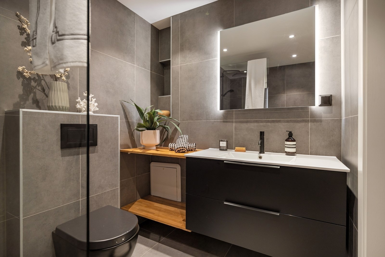 Baderommet har innredning med nedfelt servant, veggmontert toalett og dusjvegger/hjørne. Galleribilde