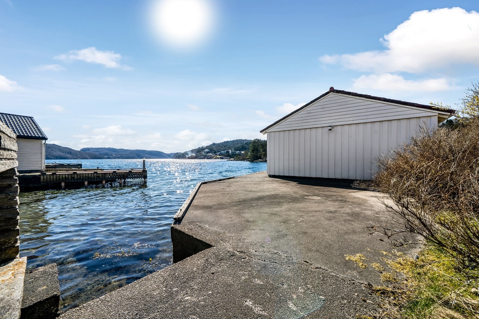 Badeplass ved sjøen og stor støpt brygge i tilknytning til båthuset. Galleribilde