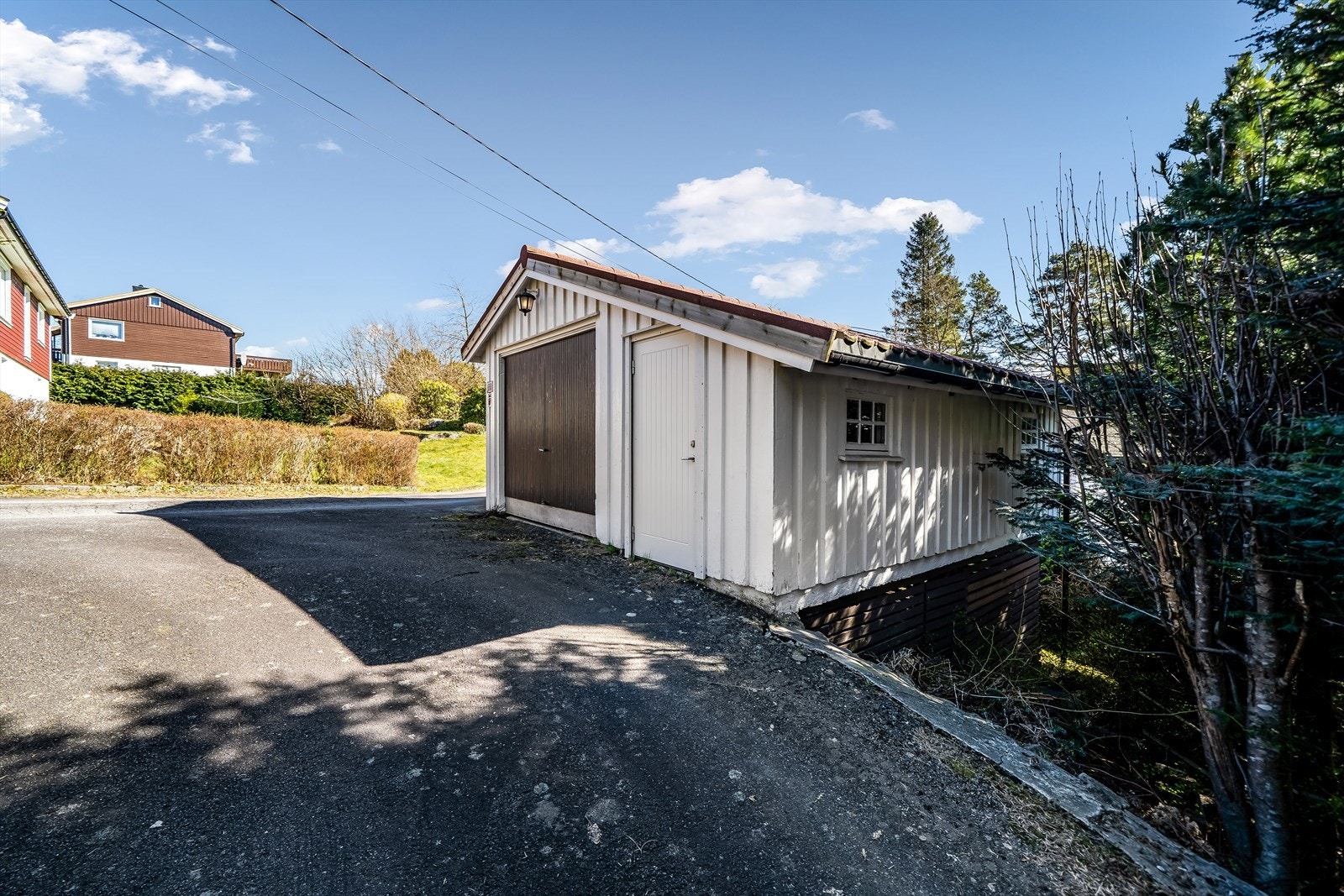 Enkel garasje med bod ved veien. Galleribilde