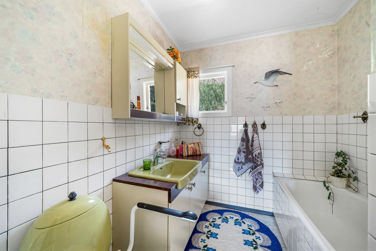 Eldre bad med baderomsinnredning, toalett og badekar. Galleribilde