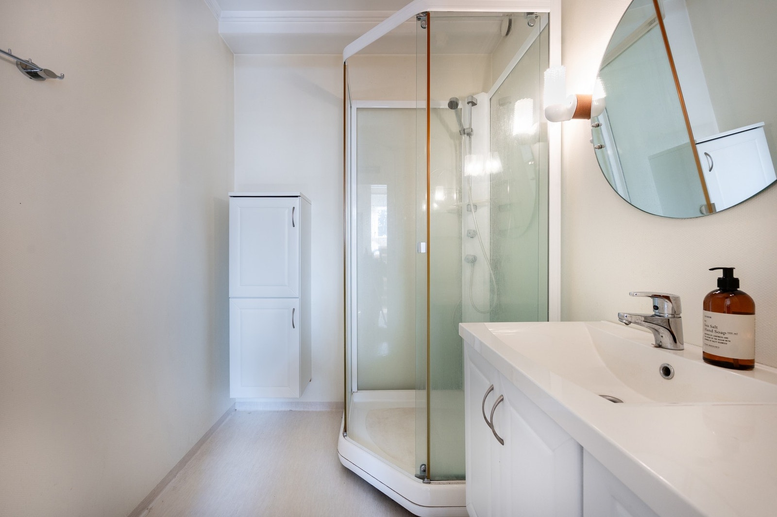 Lyst bad innredet med servantinnredning, speil og dusjkabinett, Galleribilde