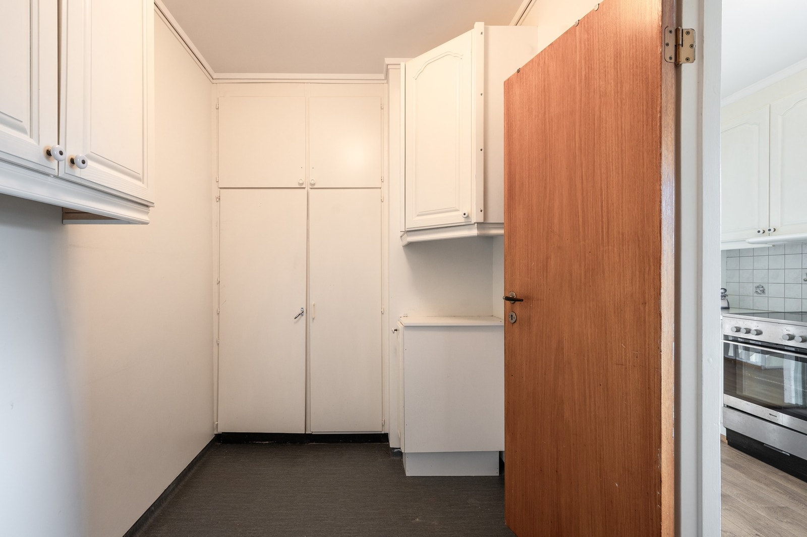 Praktisk vaskerom med vegghengt skapinnredning og utslagsvask innenfor kjøkkenet. Galleribilde