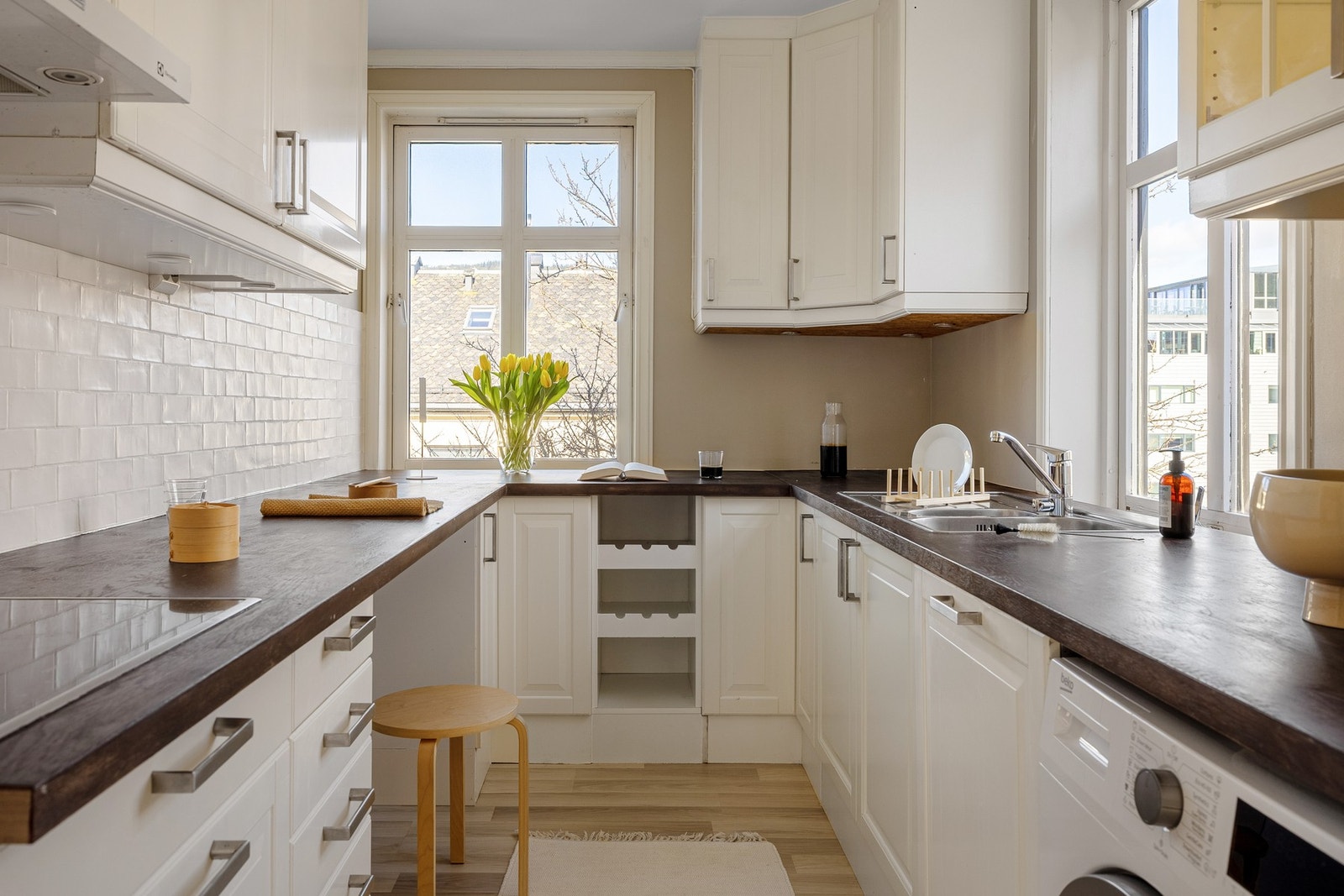 Videre til kjøkkenet med profilerte fronter, stilige glasskap og benkeplate i tre med nedfelt vask i stål. Galleribilde