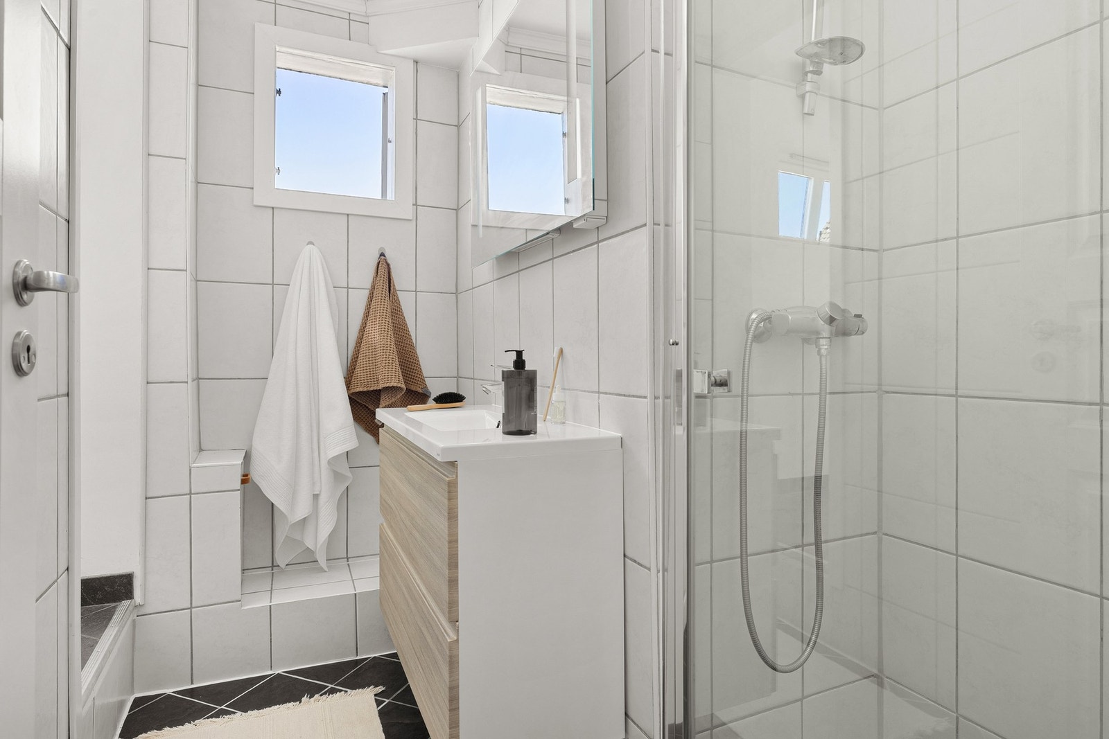 Rommet er innredet med toalett, dusj med glassdører og moderne baderomsinnredning. Galleribilde