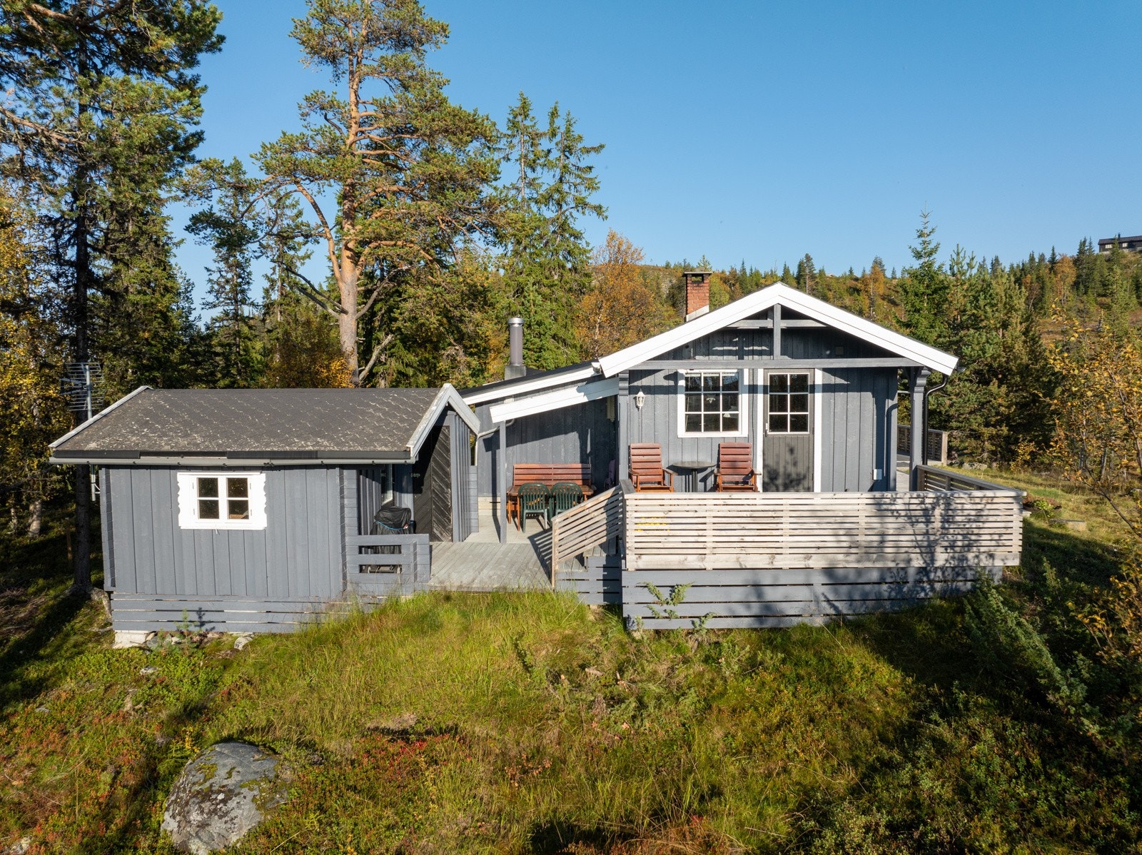 Terrassen går over flere nivåer og binder hytta sammen med et uthus og et hendig anneks - et fint gjestehus med soverom. Galleribilde