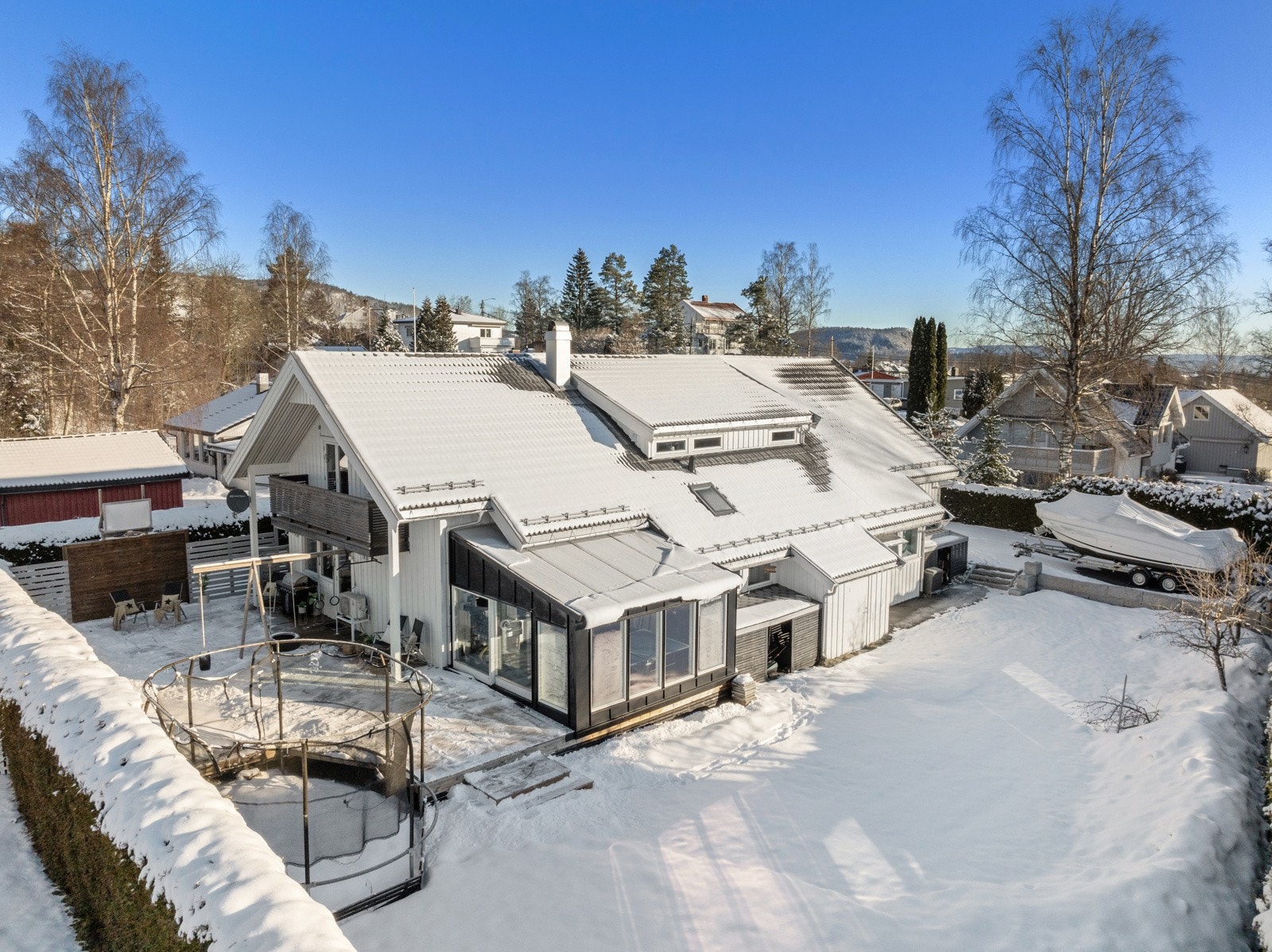 Stor flat tomt omkranser boligen. Pent opparbeidet med stor gårdsplass, terrasser og hage. Galleribilde