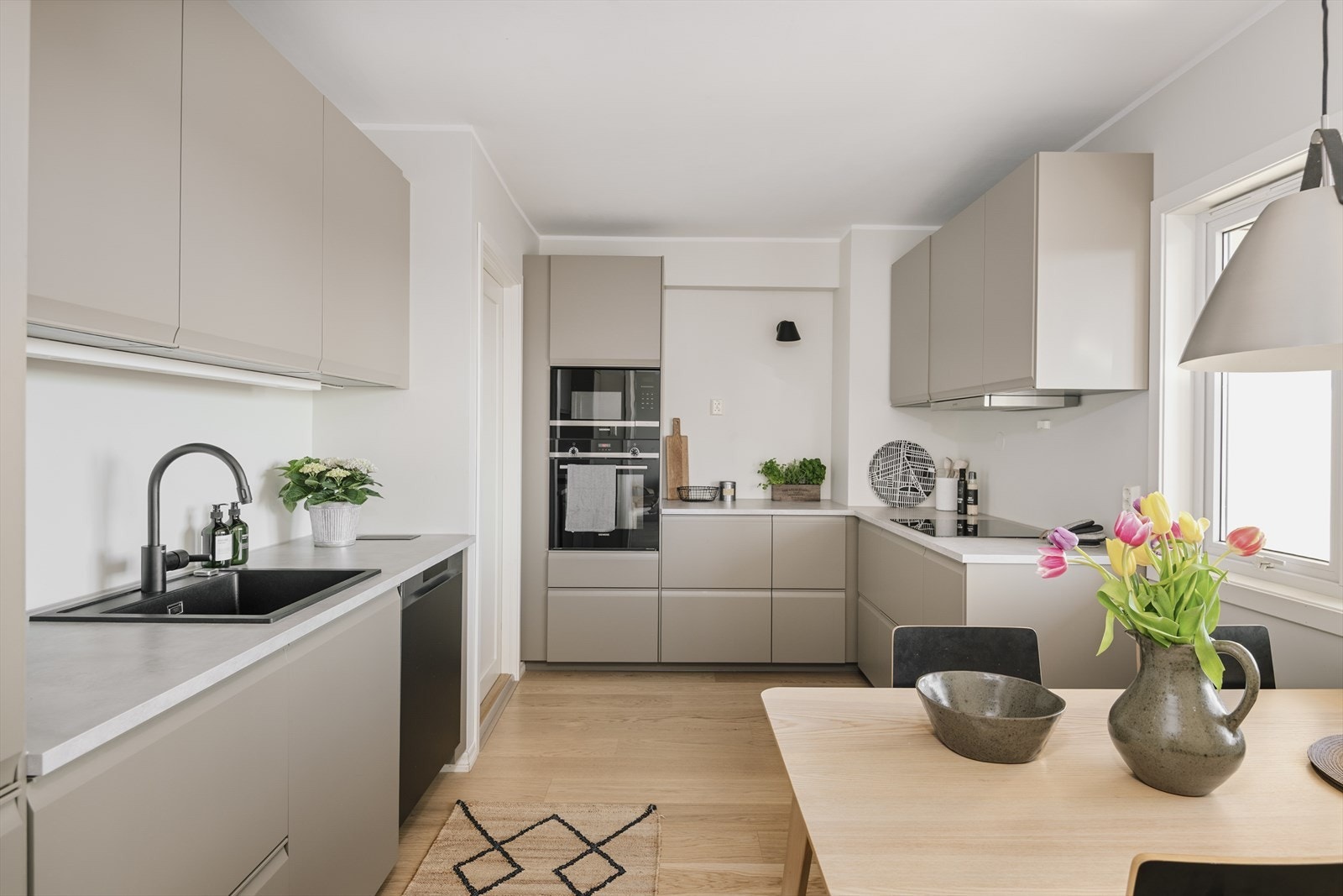 Moderne og stilrent kjøkken fra IKEA, nytt i 2023 med laminert benkeplate. Det er glatte fronter og ventilator med mekanisk avtrekk. Galleribilde