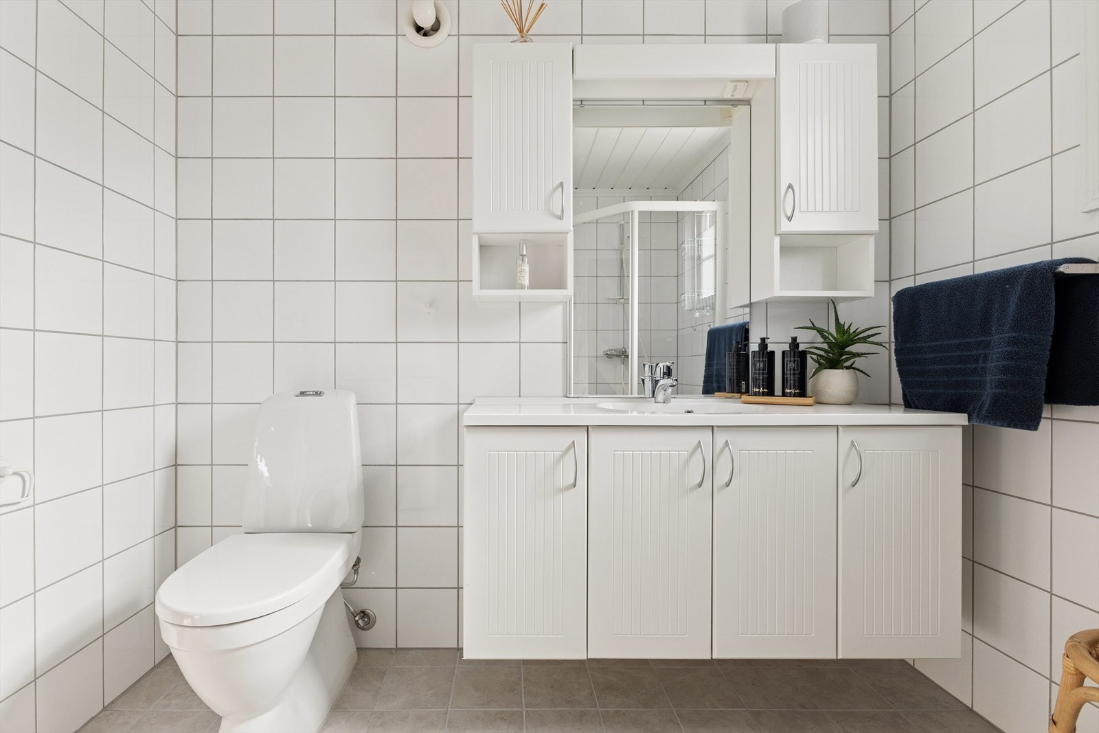 Det kombinerte badet og vaskerommet i hovedetasjen er flislagt og har behagelig elektrisk gulvvarme, som gir en varm og komfortabel opplevelse. Galleribilde