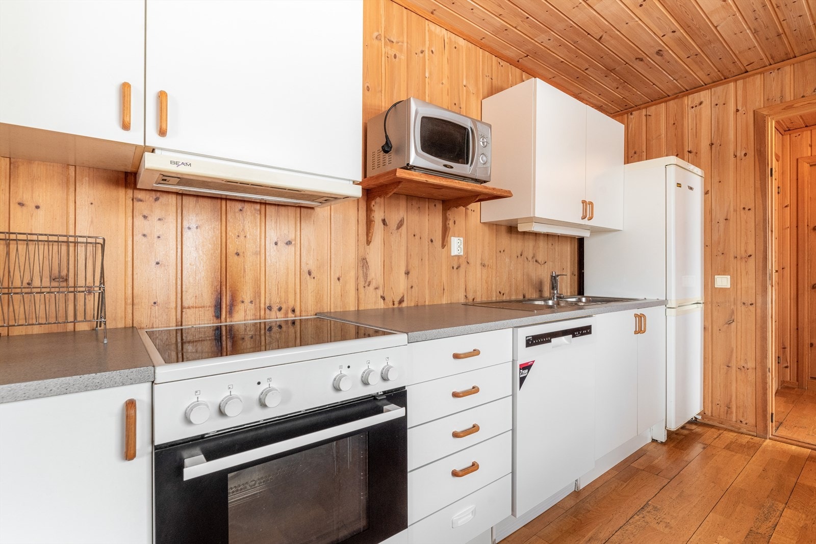 Kjøkkenet har en enkel innredning med slette fronter og laminat benkeplate. Det er avsatt plass til komfyr, oppvaskmaskin og kjøleskap. Ventilator med avtrekk ut. Galleribilde