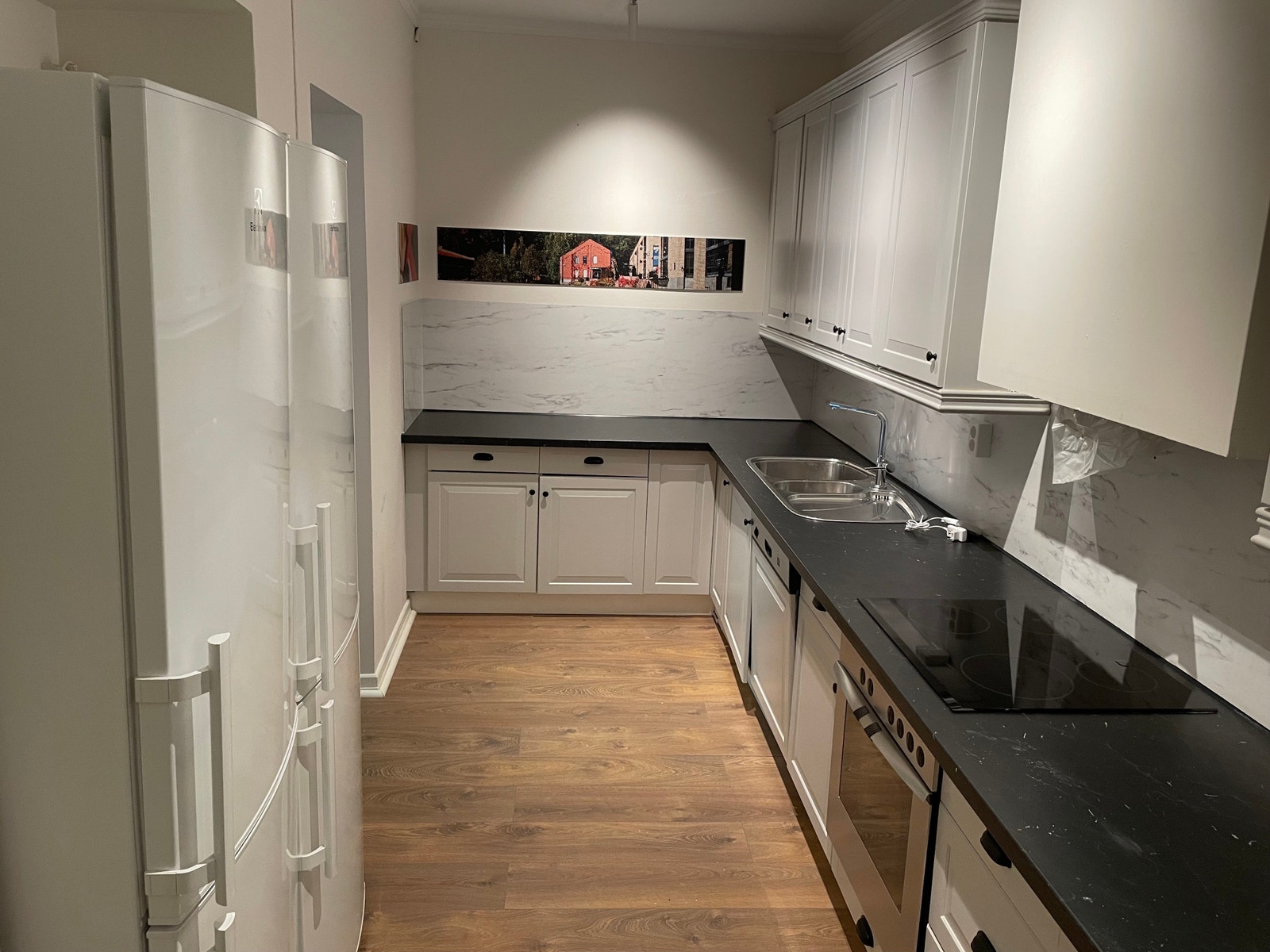 Felles kjøkken med 2 kjøleskap, komfyr, oppvaskmaskin og mye skapplass og benkeplater. Galleribilde