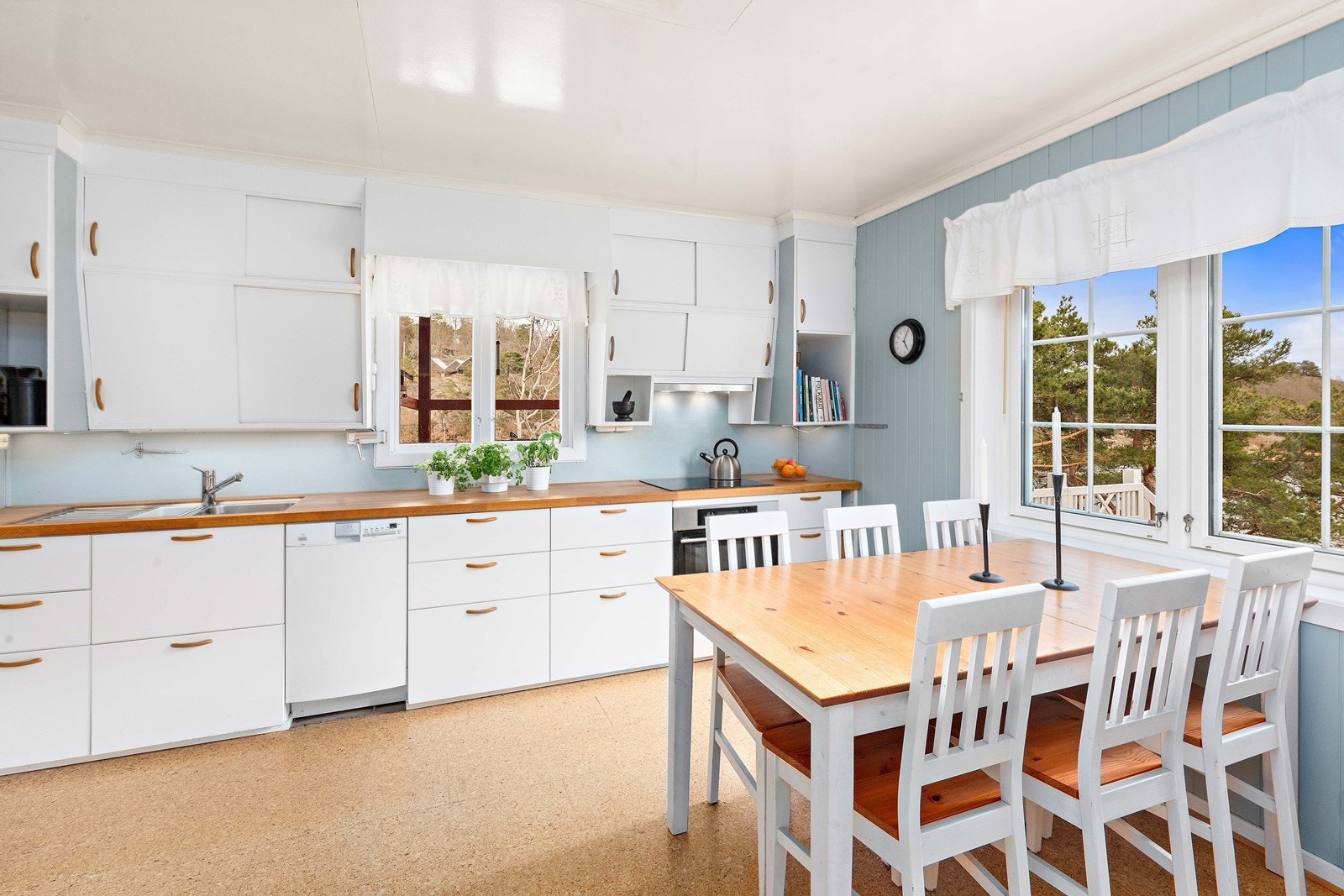 Kjøkkenet er lyst og hyggelig, med spiseplass ved vinduet. Moderne kjøkkeninnredning fra IKEA er sømløst kombinert med de originale overskapene i heltre. Galleribilde