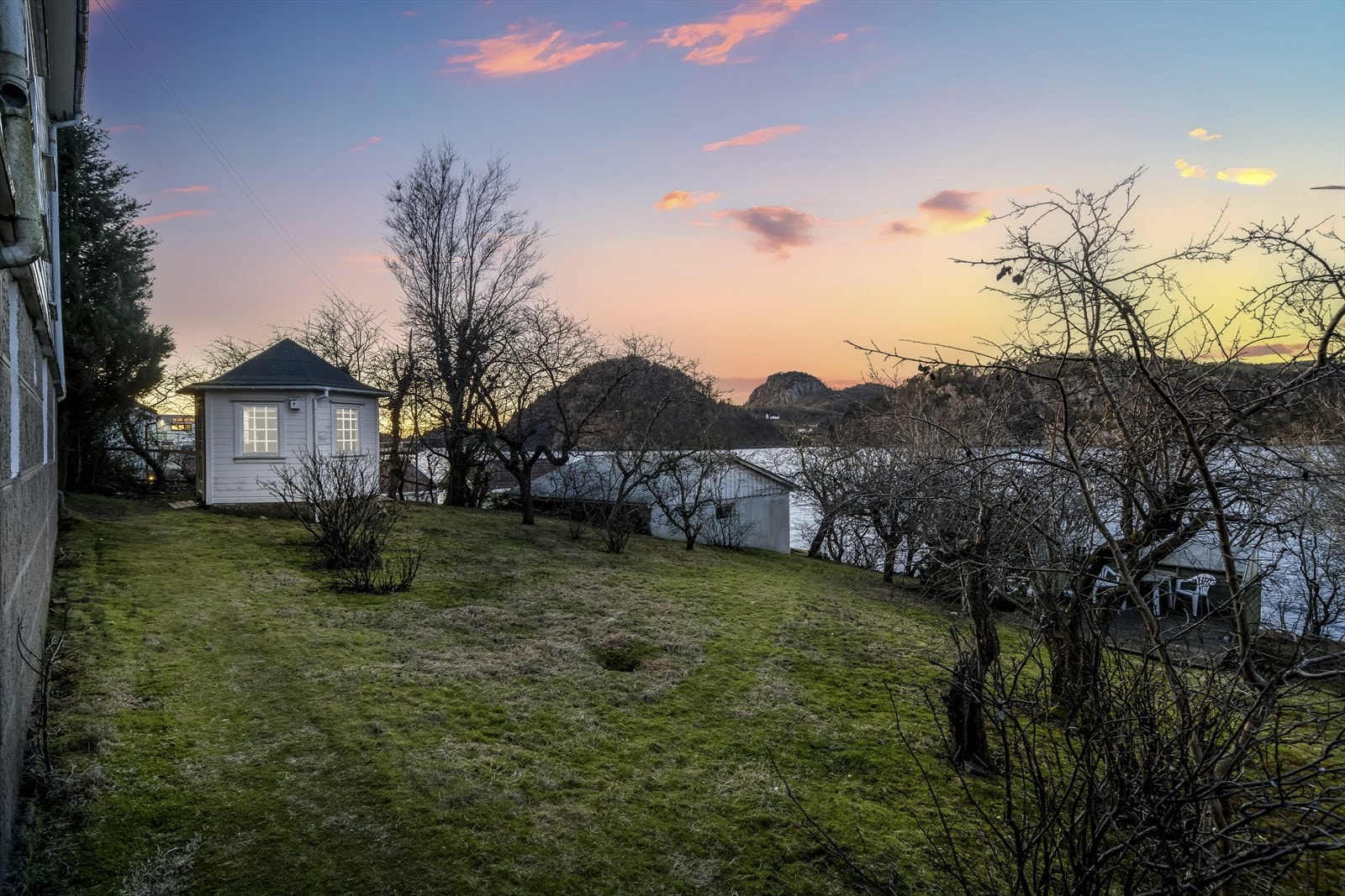 Spennende uteområde med stort plenlagt område, beplantning og strandlinje. Galleribilde