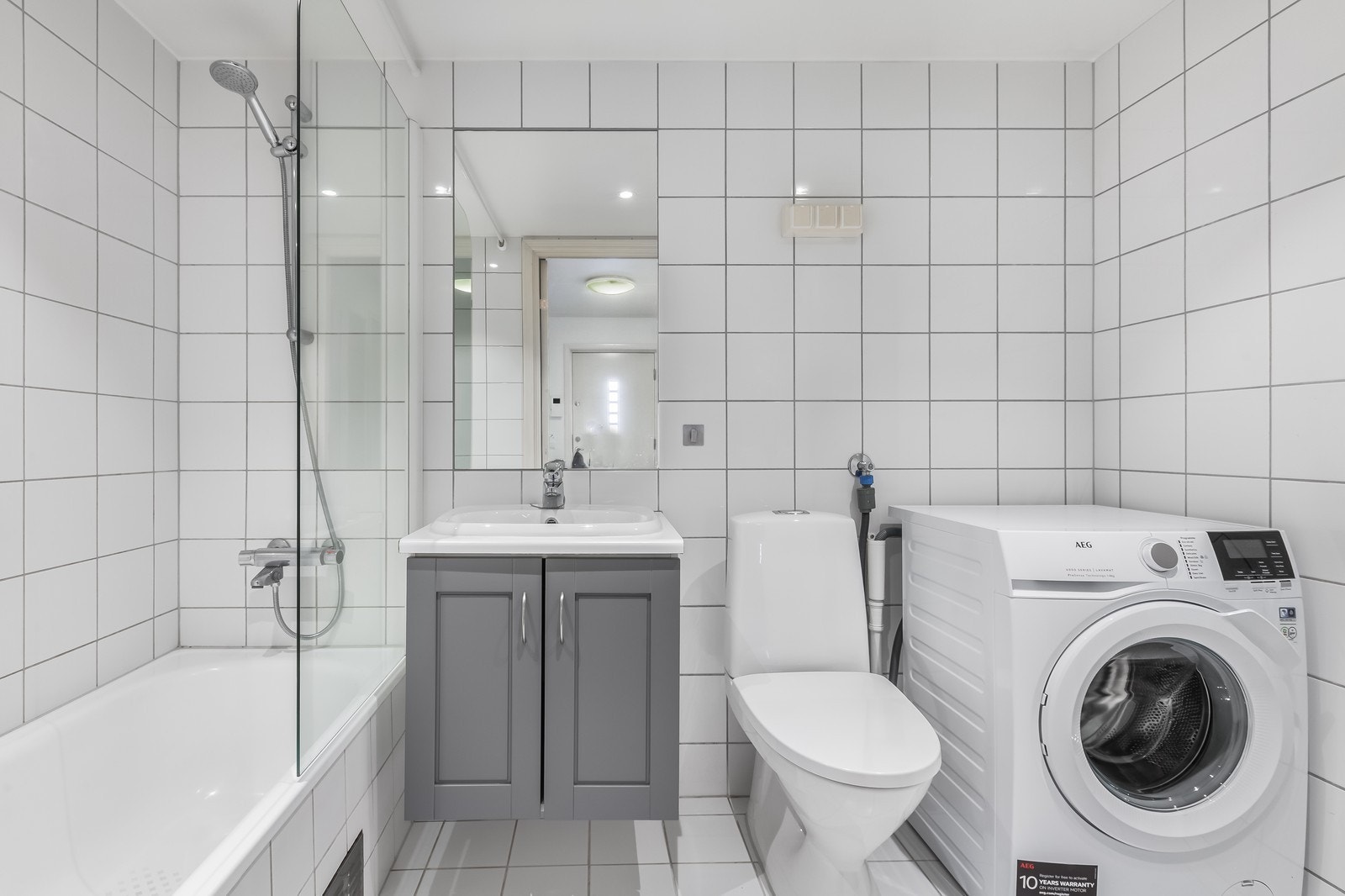 Bad med badekar og vaskemaskin. Galleribilde