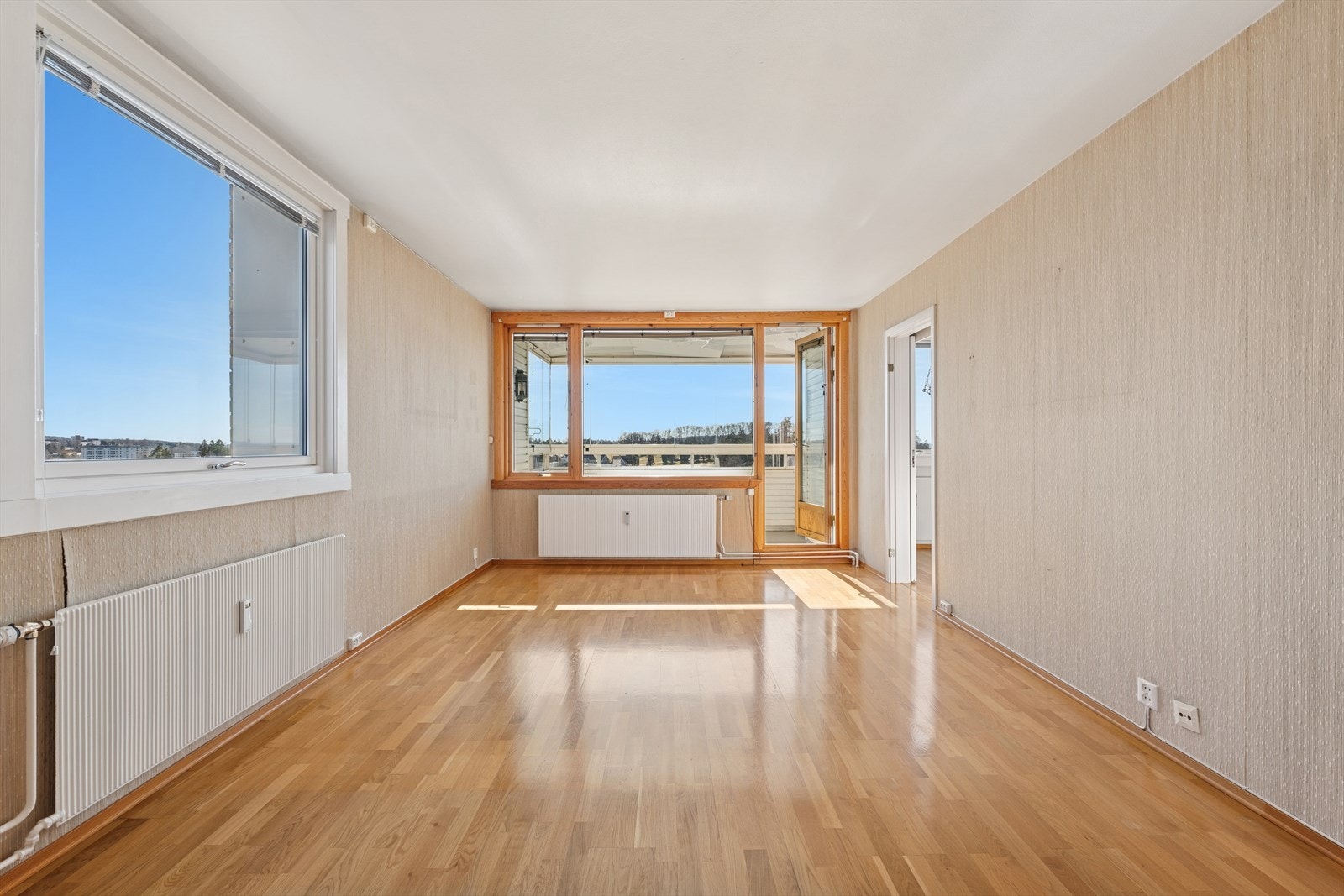 Stuen har en møbleringsvennlig planløsning med plass til sofa og spisebord. Det er store vinduer som slipper inn mye lys, noe som gjør rommet luftig og åpent. Galleribilde