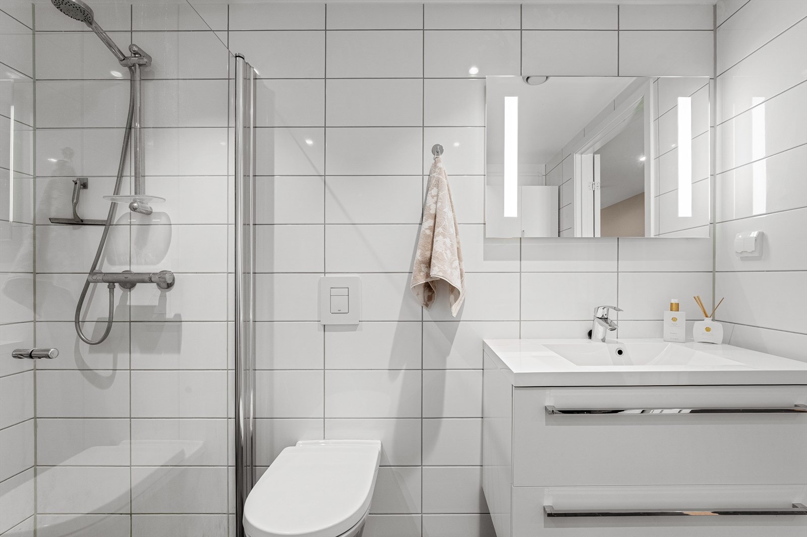 - Badet inneholder vegghengt toalett, benkeskap med servant, dusjdører i glass og fordelerskap til "rør i rør" vannforsyning - Galleribilde