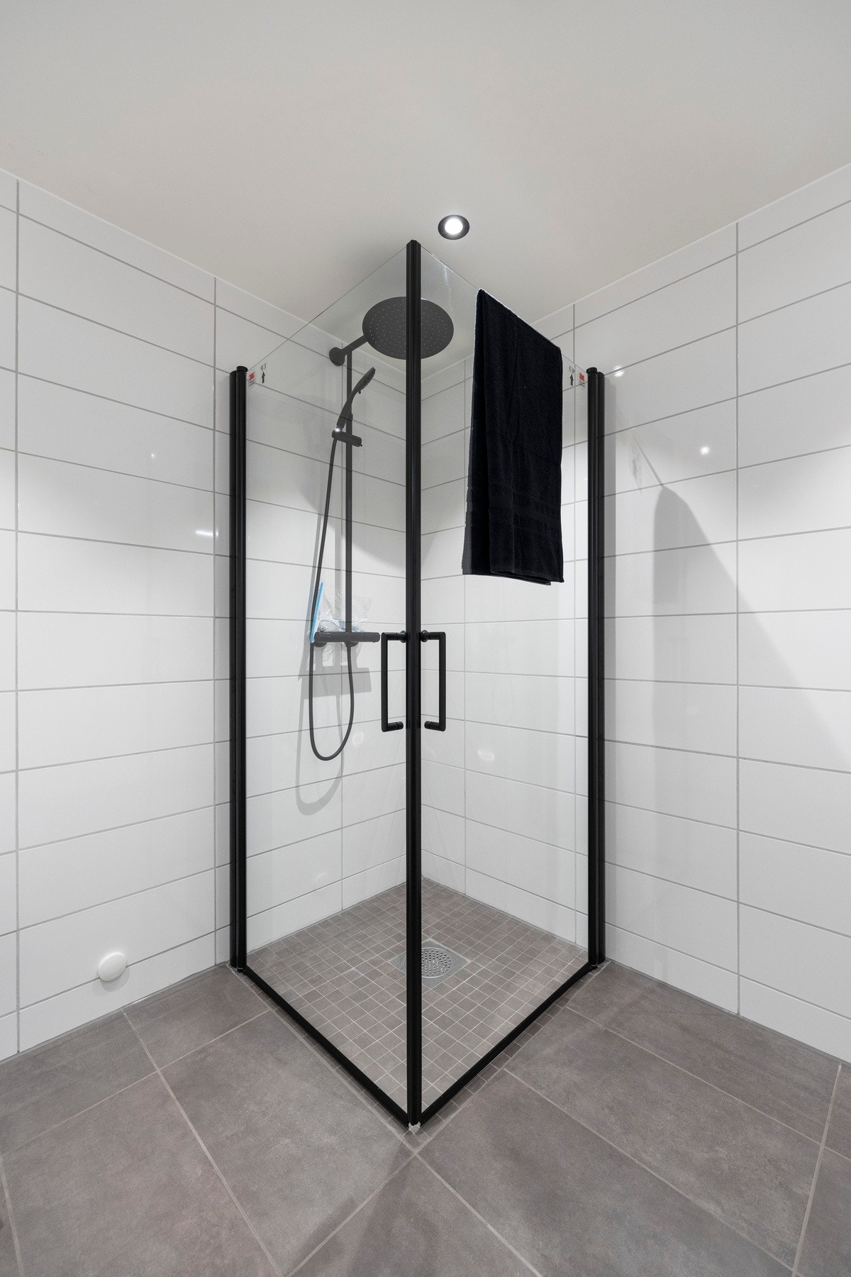 Badet har ledspotter i taket og flislagt gulv med varme Galleribilde